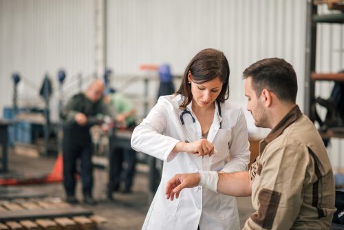 Beautiful female doctor examining factory worker.